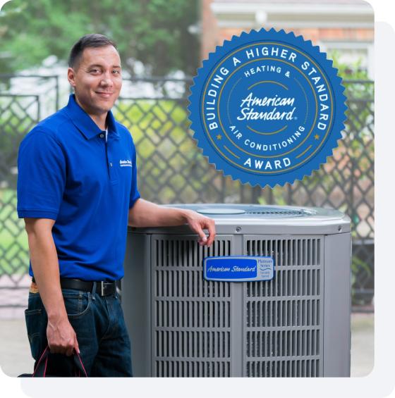 An American Standard Heating & Air Conditioning dealer standing by an outdoor HVAC unit.