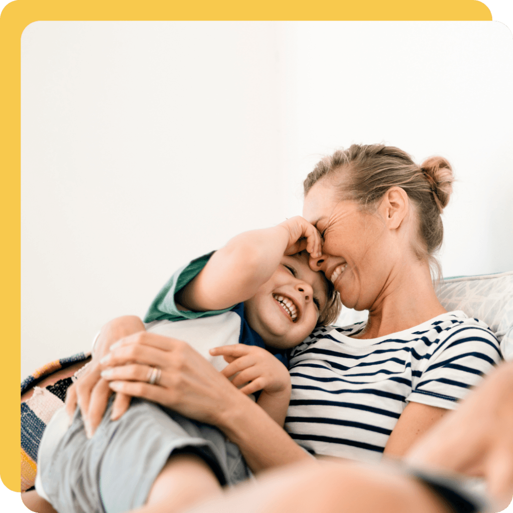 A mother snuggling with her son in their comfortably heated home.