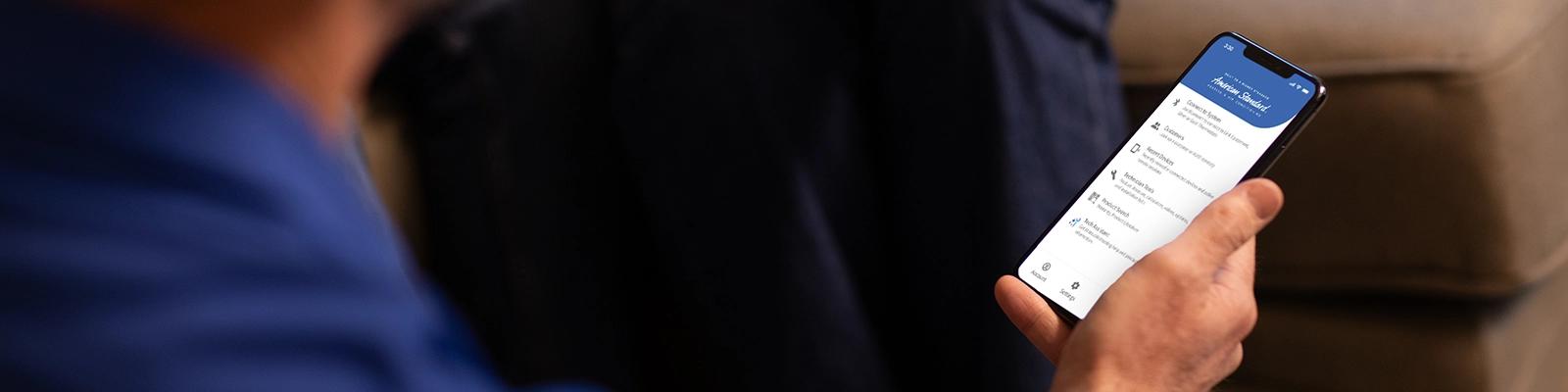 : HVAC Technician Holding a Smartphone with the HVAC Troubleshooting App Displayed