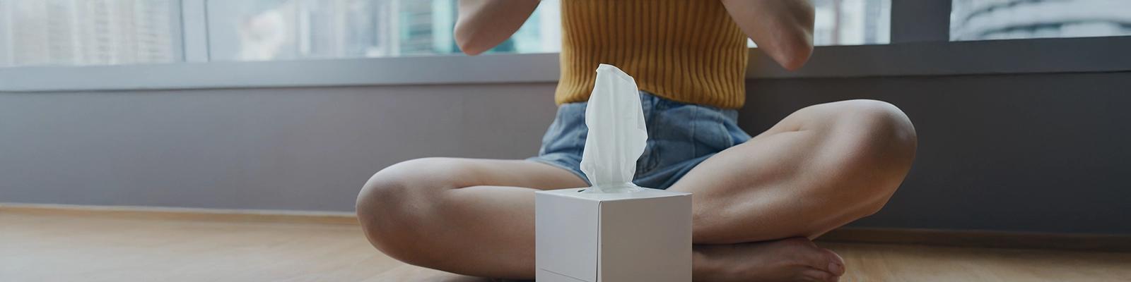 Woman Sitting Inside with a Box of Tissues