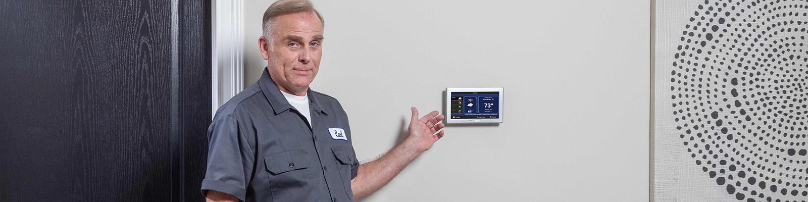 HVAC Technician in Front of an American Standard Smart Thermostat